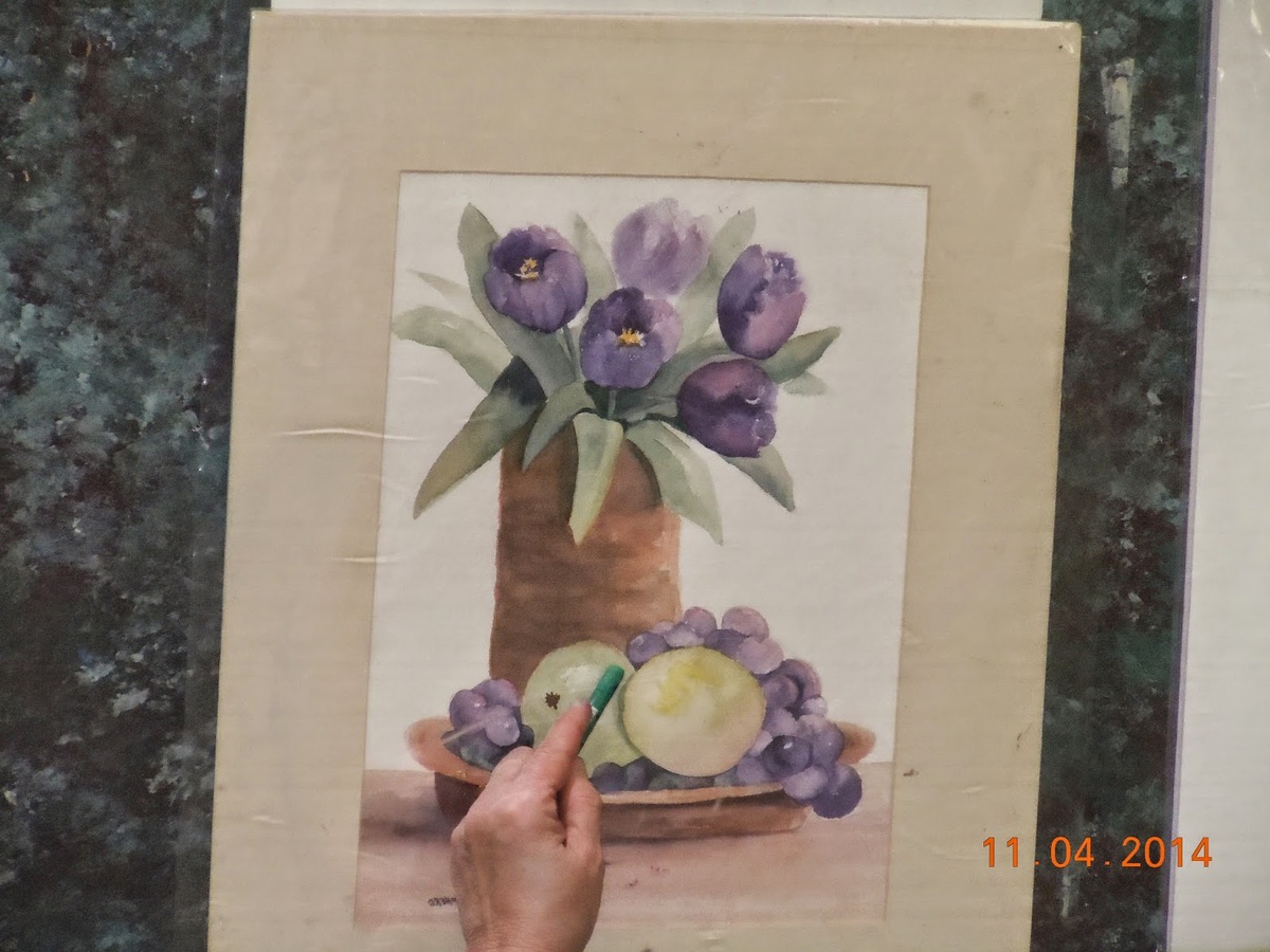 Grapes and two larger fruits sit at the base of potted purple tulips